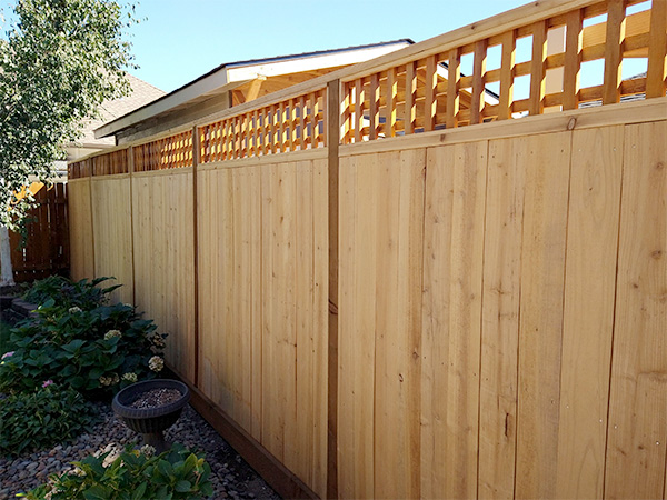 Wooden fence with slatted pattern at top